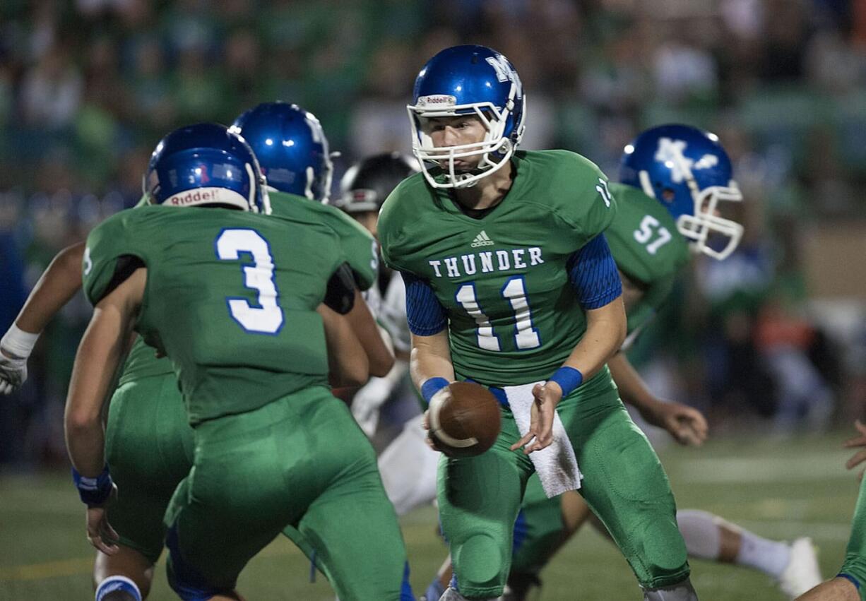 Mountain View's Colin Biggs (11) hands off to teammate Anthony Ramirez (3) in the second quarter Friday night, Oct. 23, 2015 at McKenzie Stadium.