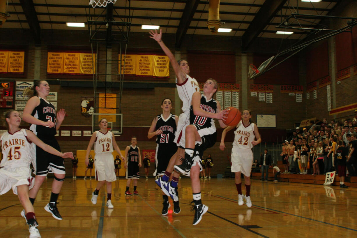 Camas senior Sydney Allen (right) soars by Prairie senior Heather Corral to score a basket Friday, at Prairie High School.