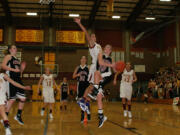 Camas senior Sydney Allen (right) soars by Prairie senior Heather Corral to score a basket Friday, at Prairie High School.