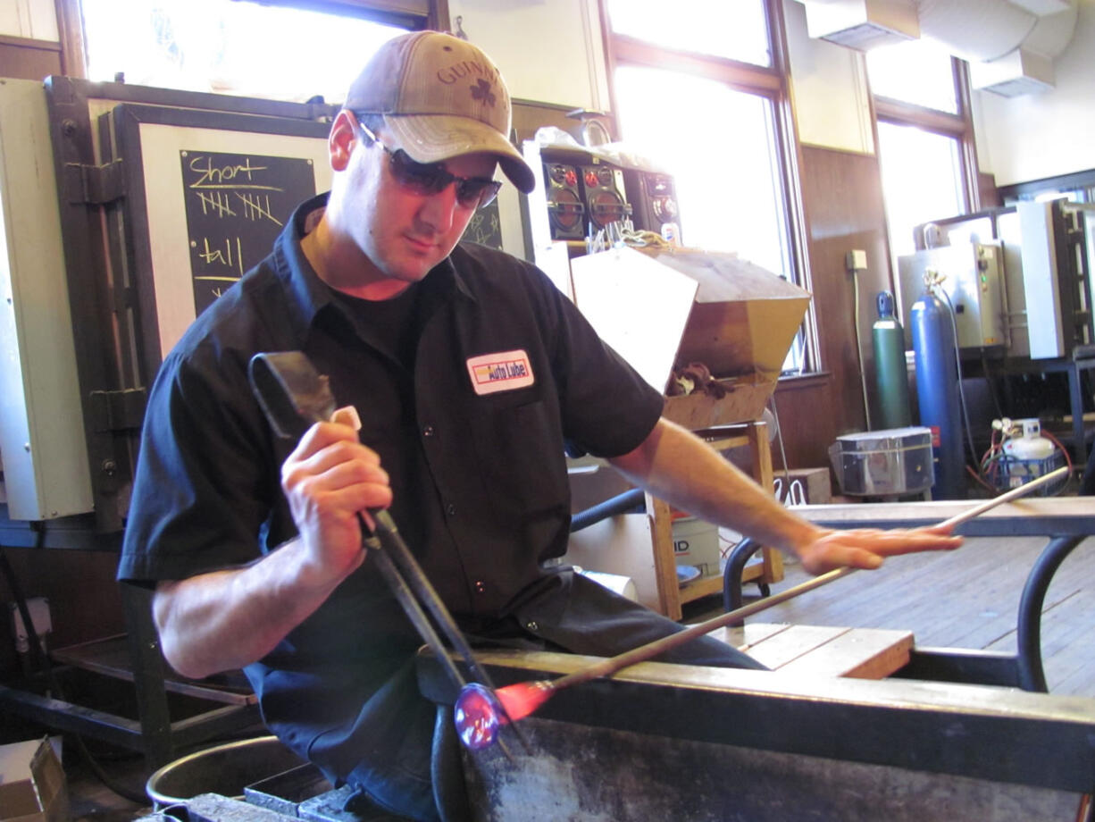 Josh Hancock, of Washougal, creates glass roses at Firehouse Glass, a studio in downtown Vancouver. He has been a glass blower for 12 years. &quot;I love it. That's why I stuck with it,&quot; Hancock said.