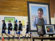 Members of the La Center Middle School's basketball team enter the gymnasium amid photographs of Cody Sherrell during a memorial ceremony at La Center Middle School in January.