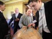 From left, Yuriy Gerasin, Russian consul general based in Seattle, talks to Valery Chkalov while Buck Heidrick of Vancouver and Igor Chkalov (the aviator's great-grandson) look at the 1937 transpolar route on a replica of a globe signed by about 80 explorers and aviators.