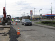 A flagger at the 100 block of &quot;C&quot; Street, in Washougal, temporarily slows traffic as crews from Northwest Natural Gas relocate a gas line in preparation for construction of a roundabout.