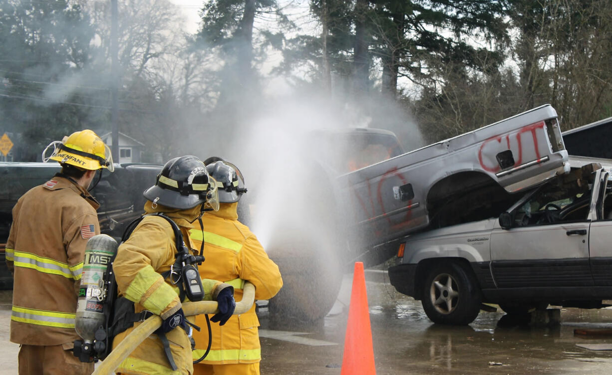 Photos courtesy of ECFR
Citizen Academy participants Martha Martin and Sheila Plato work with ECFR Intern Fire Fighter/EMT Reece Bonenfant to extinguish a fire in the cab of a pick-up truck.  The group learned how to handle charged fire hoses while safely approaching vehicle fires.  Exploding pressure cylinders in &quot;low impact bumpers&quot; can seriously injure emergency responders as firefighters approach vehicles at angles to avoid flying bumpers and rocketing cylinders.  The 1.75-inch fire hoses, used to extinguish vehicle fires, deliver 180 gallons of water per minute at a nozzle pressure of 100 psi.