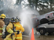 Photos courtesy of ECFR
Citizen Academy participants Martha Martin and Sheila Plato work with ECFR Intern Fire Fighter/EMT Reece Bonenfant to extinguish a fire in the cab of a pick-up truck.  The group learned how to handle charged fire hoses while safely approaching vehicle fires.  Exploding pressure cylinders in &quot;low impact bumpers&quot; can seriously injure emergency responders as firefighters approach vehicles at angles to avoid flying bumpers and rocketing cylinders.  The 1.75-inch fire hoses, used to extinguish vehicle fires, deliver 180 gallons of water per minute at a nozzle pressure of 100 psi.