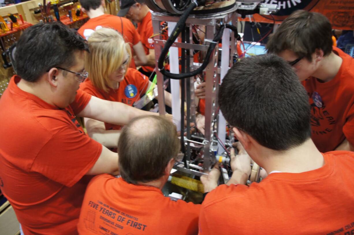 Contributed photo
Members and mentors of  Team 2471 &quot;Team Mean Machine,&quot; a Camas based FIRST Robotics team, confer during the regional competition in Seattle. The team, which includes  students from Camas, Washougal and Hockinson high schools, took first in the three-day event and will be advancing to the world championships at the end of the month.