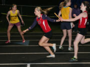 Savanna Joyce hands the baton off to Austen Reiter during the final race of the John Ingram Twilight track and field meet Friday, at Columbia River High School.