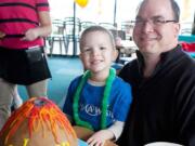 Washougal resident Coleman Merle, 5, sits with his dad, Tim, during a Make-A-Wish Oregon party held at Beaches Restaurant in Vancouver on Friday.