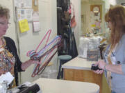 A volunteer assists a customer with a purchase at the Inter-Faith Treasure House thrift store, in Washougal.