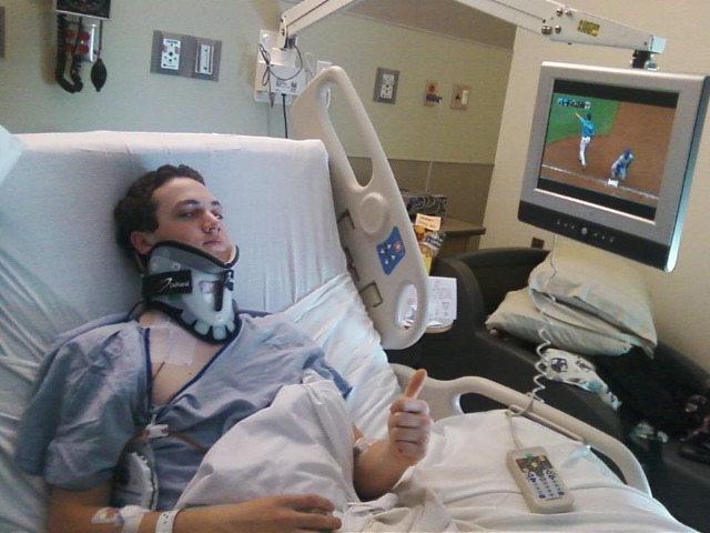 Michael Capps gives a thumbs-up as he rests in his hospital bed following his car crash last fall that left him with a broken neck.