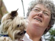 Pet acupuncturist Greta McVey holds a dog, Puff, in her home office in College Park, Md.