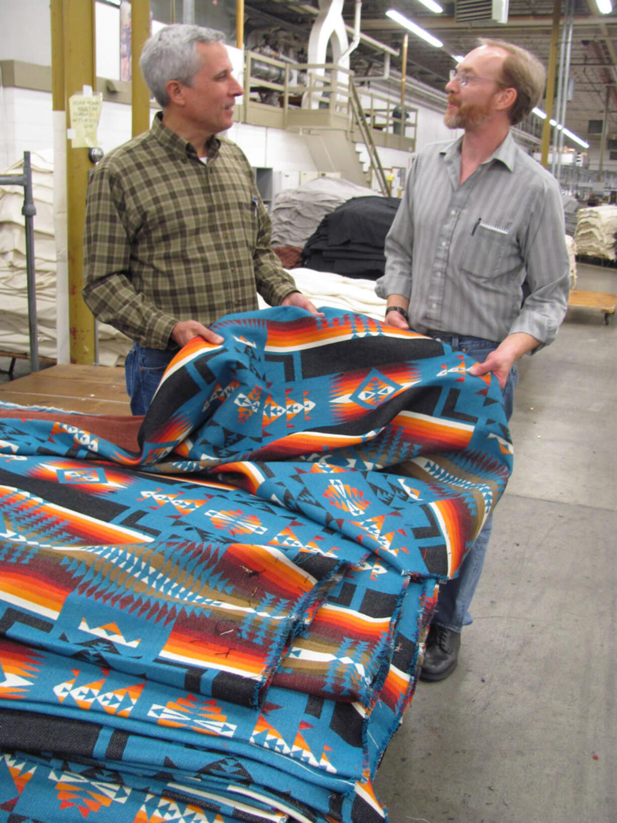 Charlie Bishop, left, vice president of mill operations at Pendleton Woolen Mill in Washougal, talks with Ted Prince, finishing supervisor. Prince has worked at the mill for 26 years.