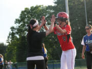 Camas senior Cali Mulholland high-fives assistant coach Ari Van Horn after her third hit of the game.