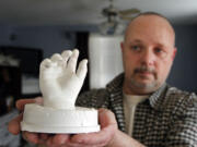 In this January photo, former Clark County Sheriff's Deputy Ed Owens holds a plaster hand casting taken from his son Ryan at the hospital shortly after his 2010 death from an accidental shooting.