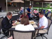 Guests enjoy salads and beverages by a warm fire Friday, during the grand opening of the Lower Terrace restaurant at Camas Meadows.