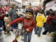 Jose Castaneda scored a new bike at the 2010 holiday party hosted by the Northeast Hazel Dell Neighborhood Association. Last year 800 children attended the community Christmas party. Not only does the party provide gifts for children, but it supplies food boxes for the needy, too.