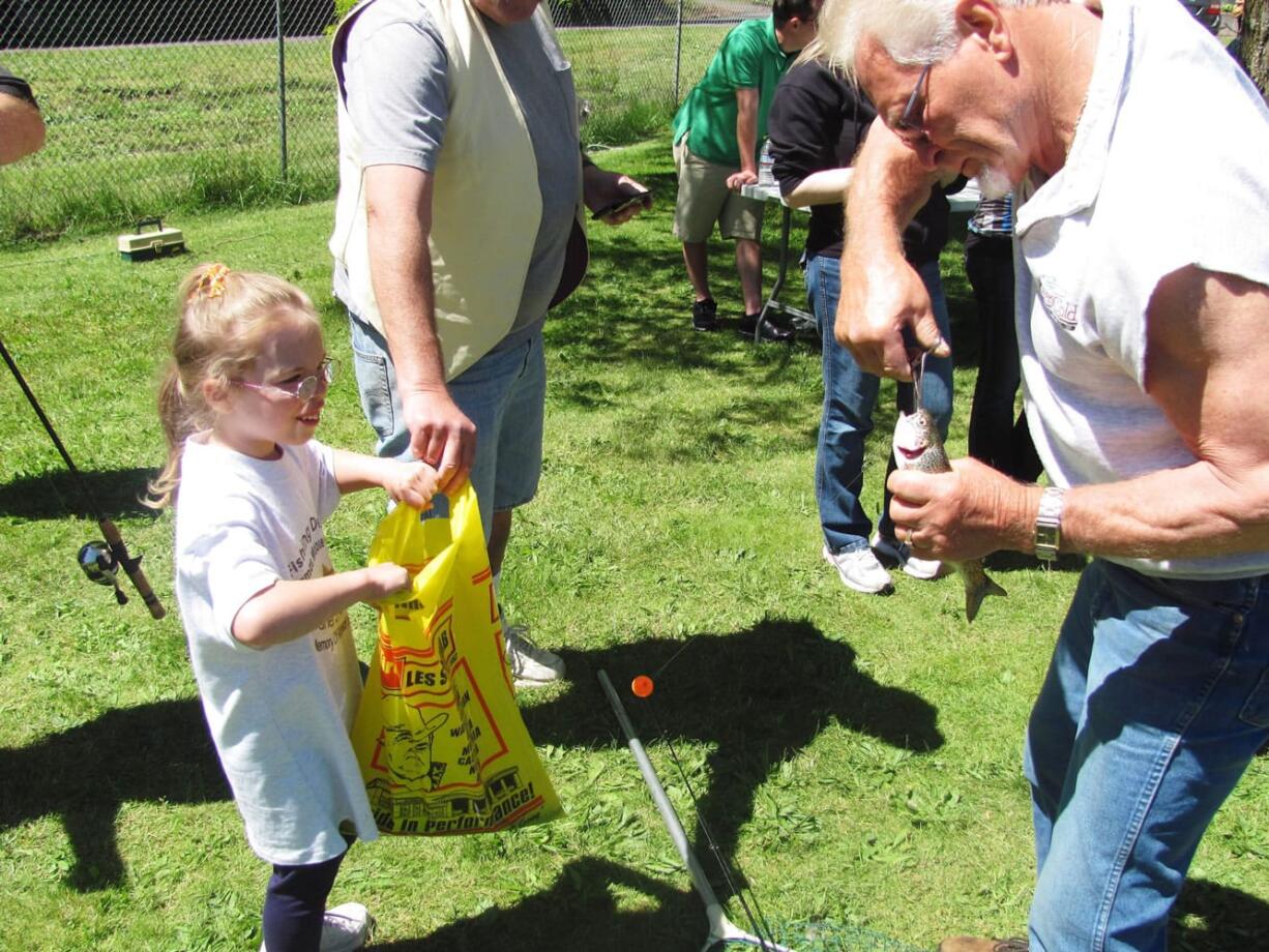 Catching a fish brings a smile to a kid's face during the 2011 Camas Moose Lodge fishing derby.