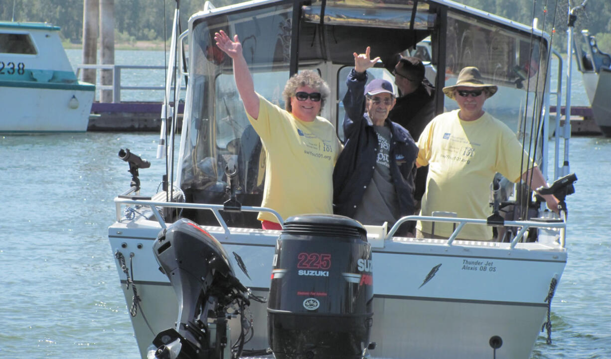 John Russell (center) sends a signal of joy to his wife and daughter Thursday, as he sails away from the Port of Camas-Washougal to go fishing for the first time in three years.