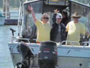 John Russell (center) sends a signal of joy to his wife and daughter Thursday, as he sails away from the Port of Camas-Washougal to go fishing for the first time in three years.