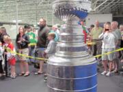 Hockey fans line up to touch the Stanley Cup Wednesday, at the Mountain View Ice Arena in Vancouver.