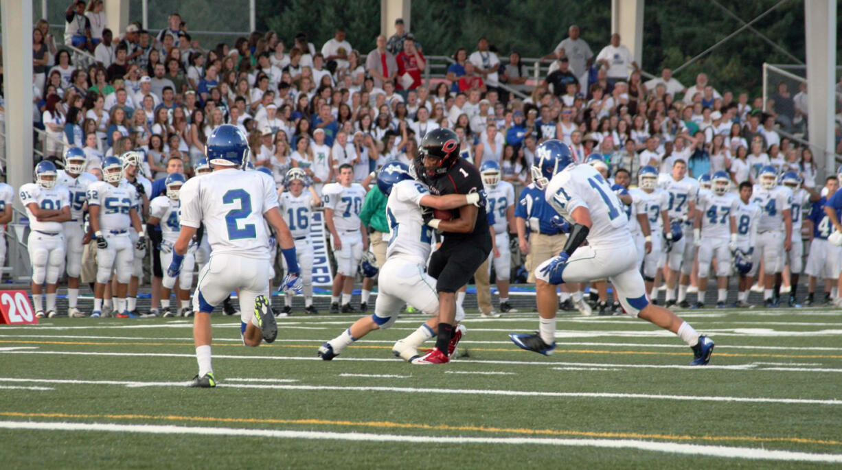 Jonathan Warner (1) bowls into a Mountain View defender Friday, at Doc Harris Stadium in Camas.