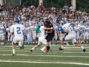 Jonathan Warner (1) bowls into a Mountain View defender Friday, at Doc Harris Stadium in Camas.