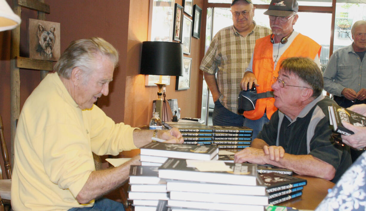 Singer, song writer and author Jimmie Rodgers (left) chats with Camas resident Barry Lutz (right) as others wait in line during a book signing event Saturday afternoon for Rodgers' autobiography &quot;Dancing on the Moon.&quot; Rodgers, a Camas native, also performed two concerts at Journey Community Church on Sunday.