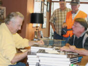 Singer, song writer and author Jimmie Rodgers (left) chats with Camas resident Barry Lutz (right) as others wait in line during a book signing event Saturday afternoon for Rodgers' autobiography &quot;Dancing on the Moon.&quot; Rodgers, a Camas native, also performed two concerts at Journey Community Church on Sunday.