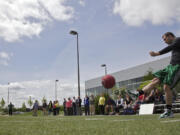 Dennison Harris kicks a ball during an employee kickball game last week at Nautilus in Vancouver.