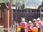 Spectators from &quot;Unified Command&quot; watch as the final 60-foot, 50,000 pound piece of steel from the derelict Davy Crockett vessel is lifted in August from the Columbia River.