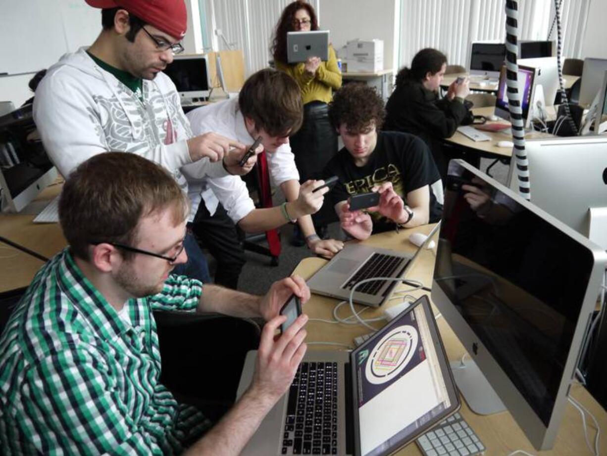 Jason Cooke
Washington  State University students Chad McClure, from left, Jacob Hochhalter, Michael Langlois and Jason Clarke, hold iPhones as they work on an exhibit on automobile technology for the Oregon Museum of Science and Industry in Portland.