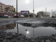 Potholes, such as this one at the intersection of West 12th and Washington streets in downtown Vancouver, are appearing countywide amid winter weather.