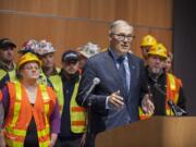 Democratic Gov. Jay Inslee, foreground, speaks to the crowd and the media Wednesday afternoon at the Vancouver Community Library.