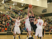 Washougal High School senior Mustapha Bah muscles up for a shot, while two Camas High School defenders try to stop him. The Panters defeated the Papermakers 64-44 Dec.