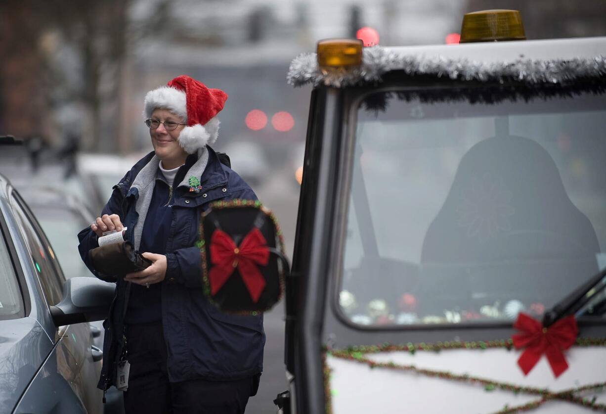 Vancouver parking enforcement officer Dareen Thielbar issues a parking ticket Wednesday on West Eighth Street.