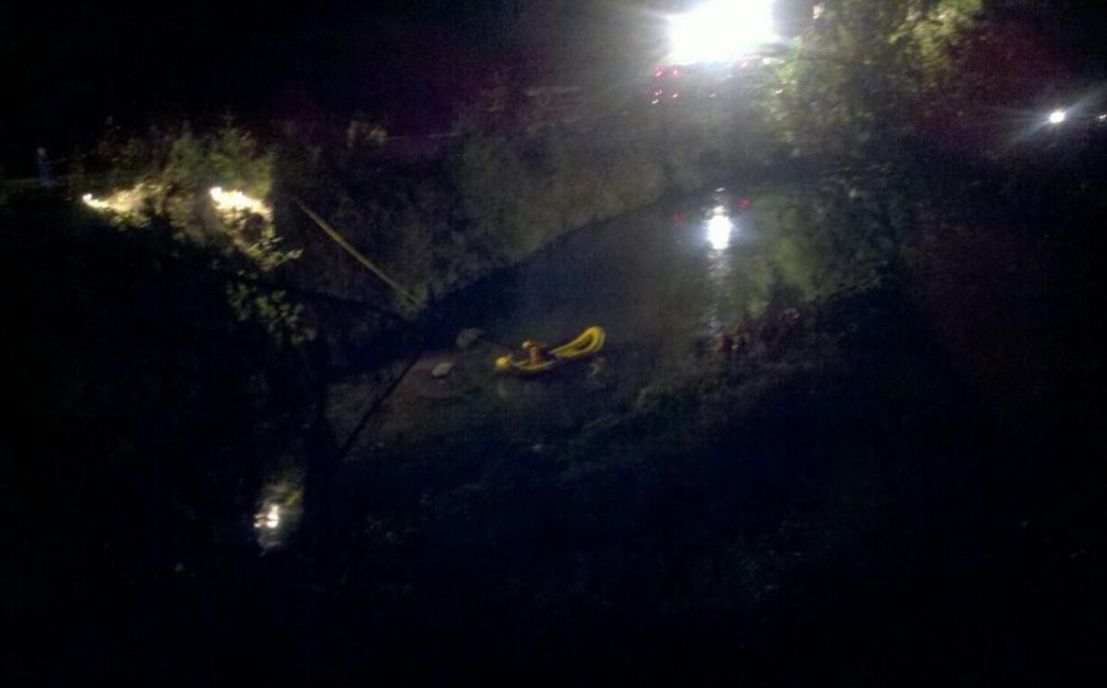 Dive team members work in a flooded gravel pit north of Battle Ground late Thursday, investigating a front end loader found wrecked in the pit by family looking for a gravel pit employee who didn't return home from work.