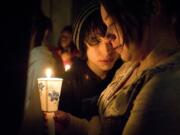 Ryan Newman, left, comforts Vivi Nikolaychuk during a candlelight vigil for their friend Eden Van Horn at Cascade Middle School.