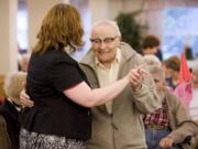 Resident Rocky Cortese, 94, dances with activities director Michelle Avdienko during a wine and cheese social hour at Vancouver's Glenwood Place Senior Living. Research suggests older people are happier than younger ones.