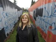 Cynthia Powers stands amid graffiti-covered shipping containers Thursday afternoon at Warrior Field in Vancouver.