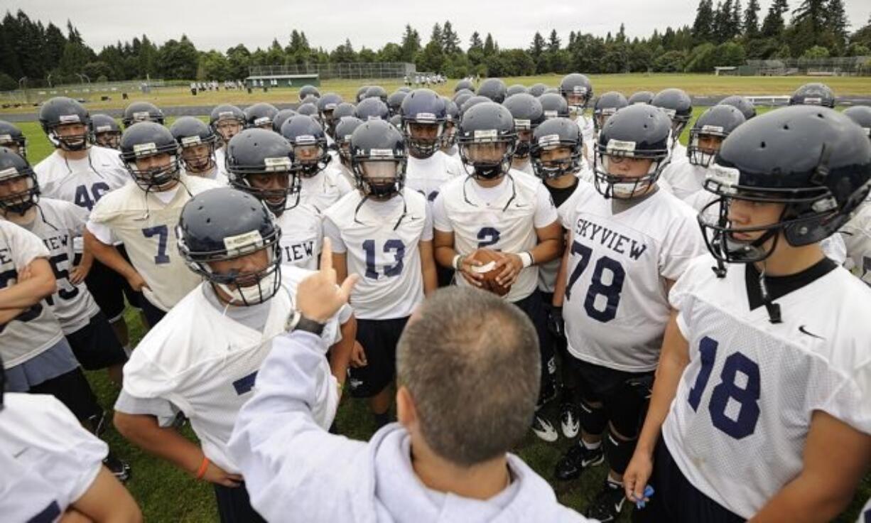 Assistant football coach Jim Gray talks to the Skyview High School football team during a break at practice Thursday August 18, 2011 in Vancouver, Washington.