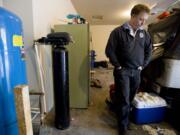 The filtration system that removes arsenic from the well water at Gordon Brooks' Amboy-area home is contained inside a black cylinder in his garage.