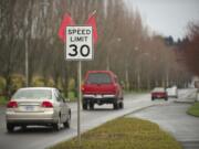 Traffic passes by a sign announcing the new 30 mph speed limit on Southeast Columbia Way in Vancouver.