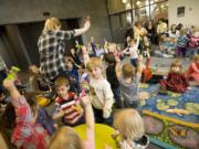 Kids shake rattles as children's librarian Kendra Jones leads them in song during Tuesday's toddler story time at the Vancouver Community Library.