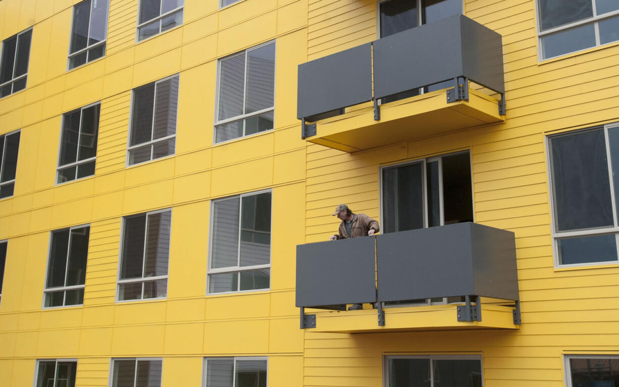 A man looks out from a balcony at 15 West Apartments, an affordable housing complex in downtown Vancouver. The 120-unit building will rent to people earning 60 percent of the median income or less.