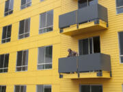 A man looks out from a balcony at 15 West Apartments, an affordable housing complex in downtown Vancouver. The 120-unit building will rent to people earning 60 percent of the median income or less.