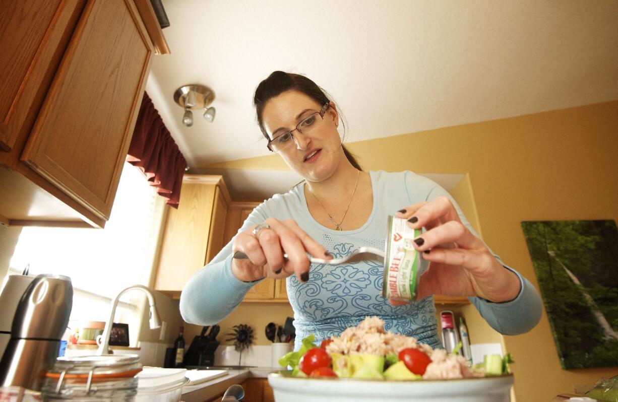 Natalie Middleton adds tuna fish to her salad while preparing lunch at her Vancouver home recently.