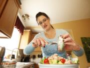 Natalie Middleton adds tuna fish to her salad while preparing lunch at her Vancouver home recently.