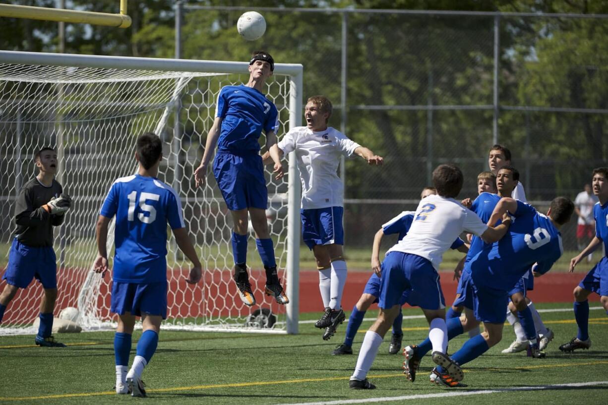 Mountain View's Peter Prescott heads away a corner kick from Jesse Moore of Bainbridge during Friday's 3A state soccer semifinal match at Sparks Stadium in Puyallup.