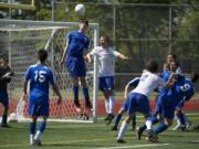 Mountain View's Peter Prescott heads away a corner kick from Jesse Moore of Bainbridge during Friday's 3A state soccer semifinal match at Sparks Stadium in Puyallup.