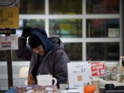 Photos by Zachary Kaufman/The Columbian Columbia River Coffee Co. owner Steven Cronbaugh bundles up Saturday at the Vancouver Farmers Market's Thanksgiving Market. Cronbaugh hates being cold, but says it's better than being hot.